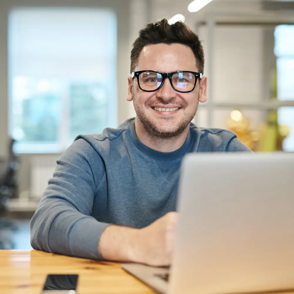 Man facing camera with computer in front of him suggesting he is working on online reviews and reputation management